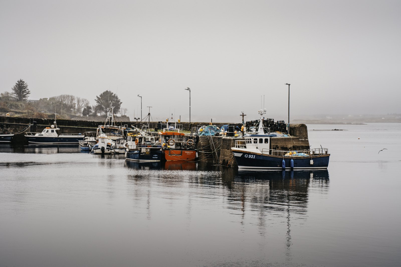 Fishing boats moored along a calm inlet on a still grey morning (placeholder photo)